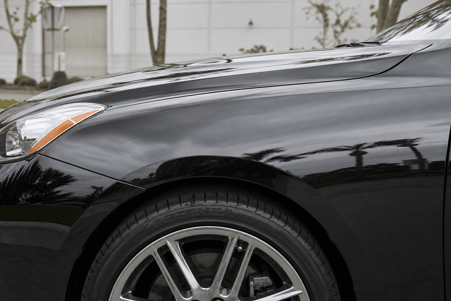 After exterior detailing — mirror gloss finish on black sedan